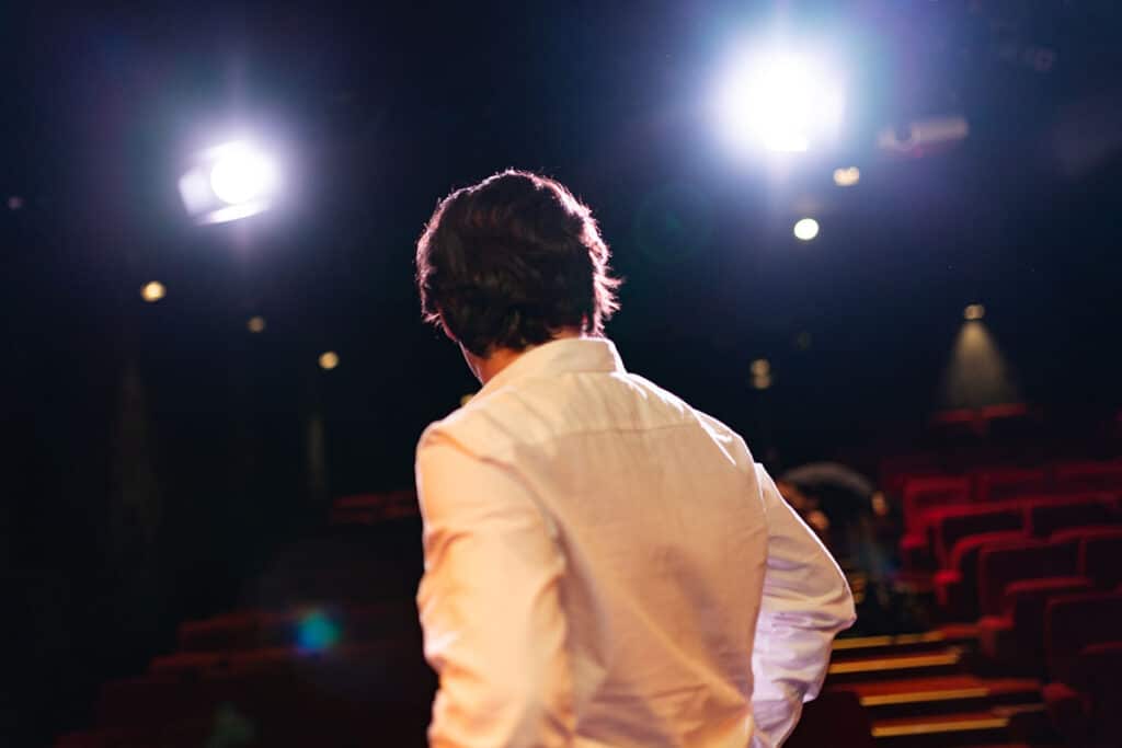 Un comédien amateur qui regarde un théâtre de manière songeuse